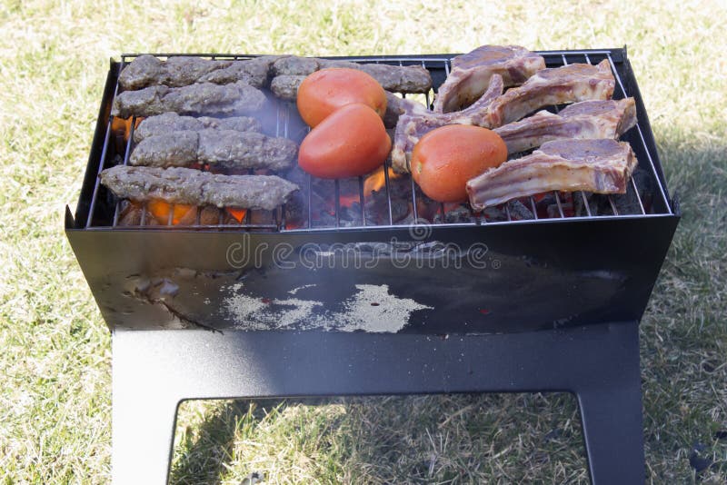 Lamb Chops, Kabobs and Tomatoes on a Charcoal Grill Stock Photo Image