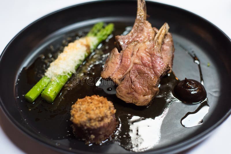 Lamb Dish Cooking with Fresh Lamb Racks from Butcher on Dark Rustic Kitchen Table at Wooden