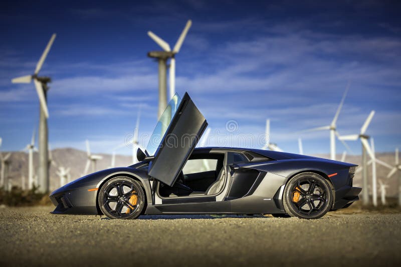 A Lamborghini Aventador opened up near a field of wind turbines. A Lamborghini Aventador opened up near a field of wind turbines.