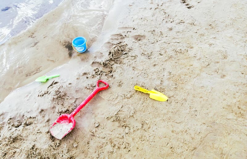 Children&#x27;s toys on the beach. Scattered on the sand are the child&#x27;s toys for pasoks. Blades and buckets for sculpting pastes on the sand. Children&#x27;s toys on the beach. Scattered on the sand are the child&#x27;s toys for pasoks. Blades and buckets for sculpting pastes on the sand.