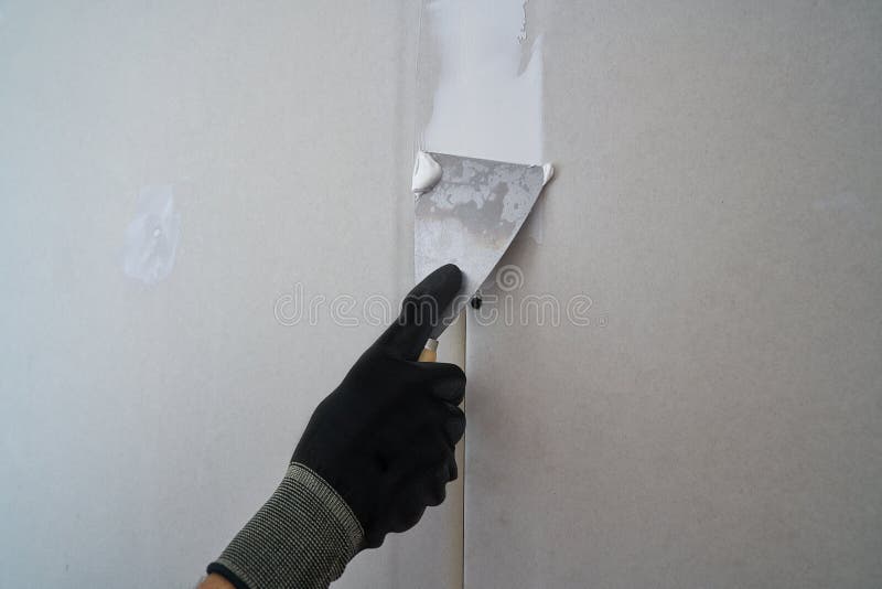 Plastering Man Hand Sanding the Plaste in Drywall Seam Stock Image