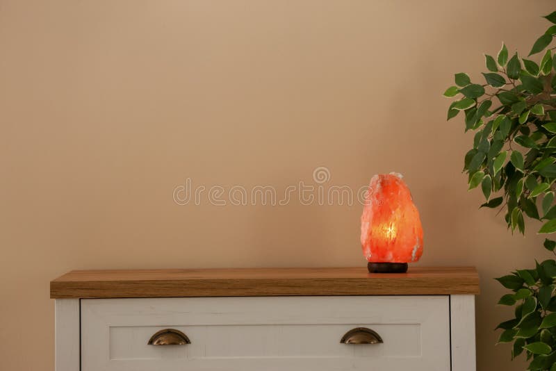 Lampada himalayana del sale sul gabinetto fotografia stock Lampada himalayana del sale sul gabinetto fotografia stock