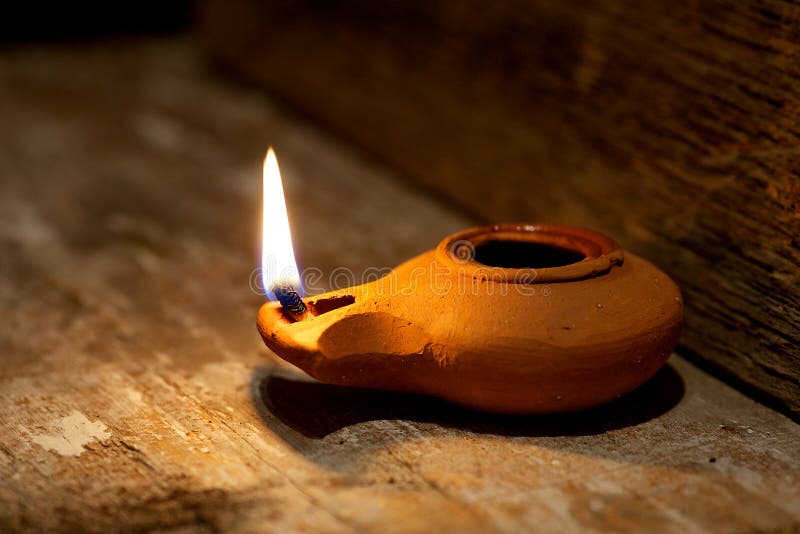 Lampada a olio del Medio-Oriente antica fatta in argilla sulla tavola di legno