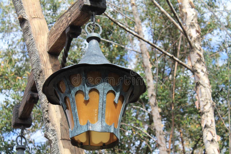 Old fashioned antique style exterior lamps and post in against trees and blue sky in the background. Disney, Orlando, Florida. closeup. Old fashioned antique style exterior lamps and post in against trees and blue sky in the background. Disney, Orlando, Florida. closeup.