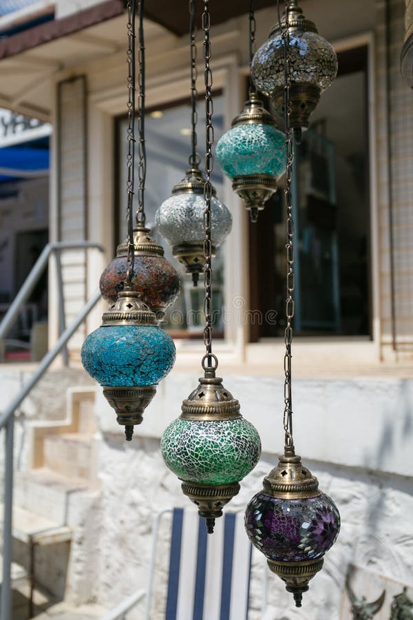 Seven traditional turkish glass mosaic hanging lamps of turquoise green purple and grey color over blurred background. Seven traditional turkish glass mosaic hanging lamps of turquoise green purple and grey color over blurred background