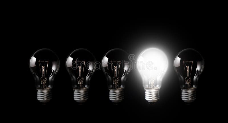 Light bulbs with glowing one outstanding dark background.Business and motivation concept ideas. Light bulbs with glowing one outstanding dark background.Business and motivation concept ideas.