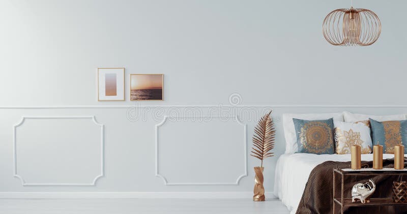 Lampe d'or au-dessus d'un lit dans l'intérieur lumineux de chambre à coucher avec le fauteuil d'or vidéo banque de vidéos