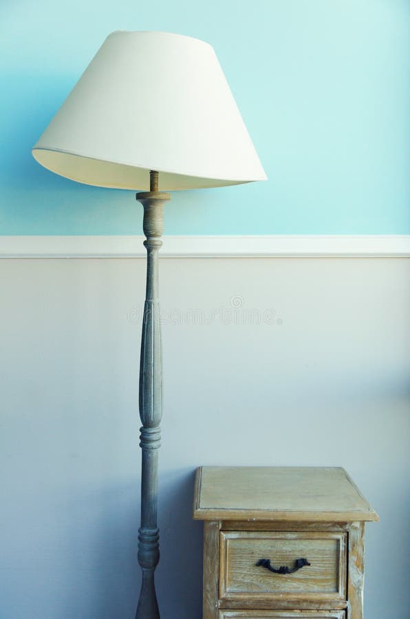 Lampe de torche de plancher, nightstand en bois, rideaux sur le fond bleu en pastel de mur Bannière avec l'espace de copie Intéri photographie stock