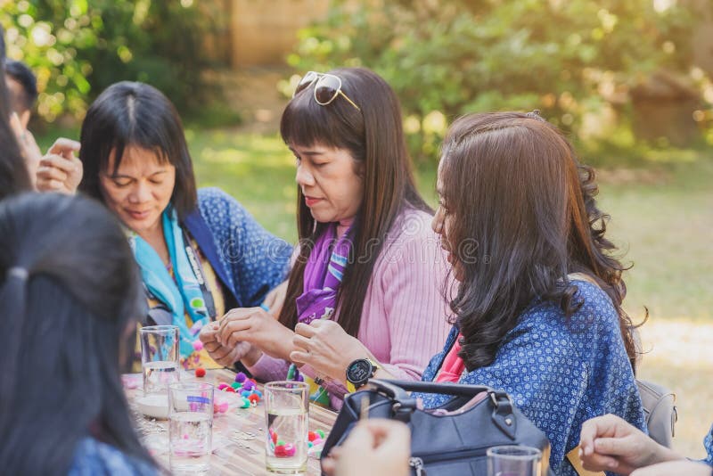 LAMPHUN TAILANDIA - 12 DE DICIEMBRE : Turistas tailandesas no identificadas aprenden a hacer un collar con una bola de hilado el fotos de archivo LAMPHUN TAILANDIA - 12 DE DICIEMBRE : Turistas tailandesas no identificadas aprenden a hacer un collar con una bola de hilado el fotos de archivo