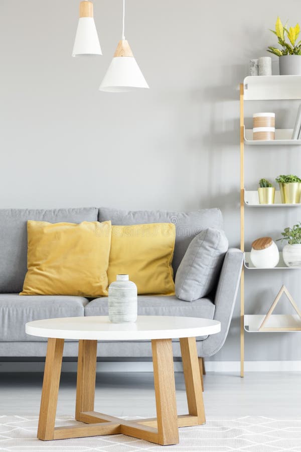 Lamps above wooden table in front of grey sofa with yellow pillo royalty free stock photo Lamps above wooden table in front of grey sofa with yellow pillo royalty free stock photo