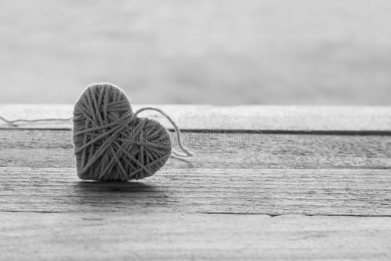 lana tricottante rosa nella forma di cuore su di legno d'annata con boke fotografie stock libere da diritti lana tricottante rosa nella forma di cuore su di legno d'annata con boke fotografie stock libere da diritti