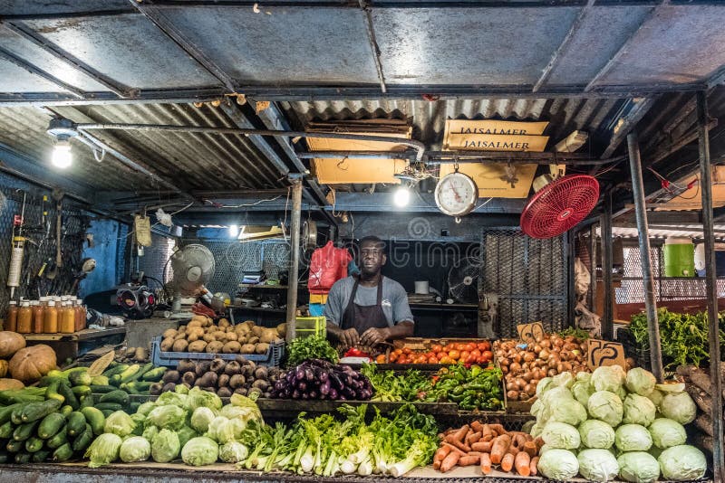 Lancez le support sur le marché, homme vendant des fruits et légumes sur le marché de nourriture dedans