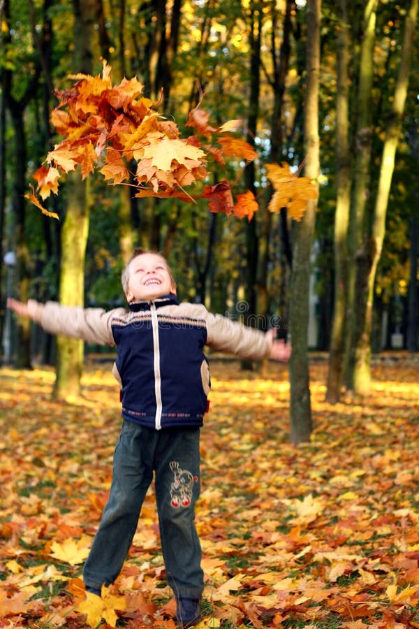 lancio dei fogli del bambino di autunno immagine stock lancio dei fogli del bambino di autunno immagine stock