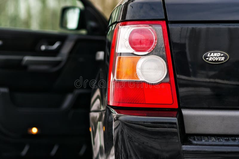 Land Aangejaagd Rover Range Rover Sport V8 De linker achterkoplamp van zwart SUV schoot close-up met geopende deur uit nadruk stock foto Land Aangejaagd Rover Range Rover Sport V8 De linker achterkoplamp van zwart SUV schoot close-up met geopende deur uit nadruk stock foto