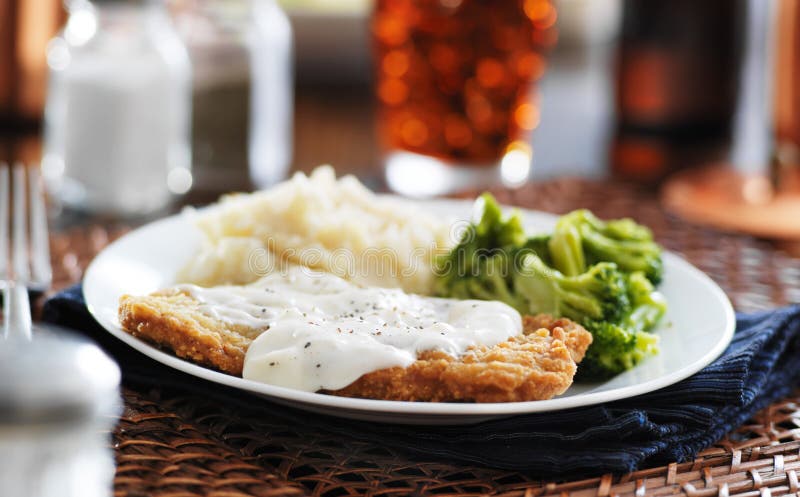 Country fried steak with southern style peppered milk gravy shot in panorama style. Country fried steak with southern style peppered milk gravy shot in panorama style