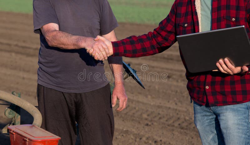 Landbouwer en ingenieurs het schudden dient gebied in stock foto Landbouwer en ingenieurs het schudden dient gebied in stock foto