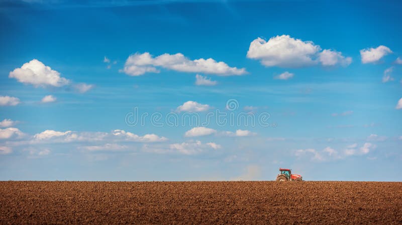 Landbouwer met tractor het zaaien gewassen bij gebied royalty-vrije stock foto Landbouwer met tractor het zaaien gewassen bij gebied royalty-vrije stock foto