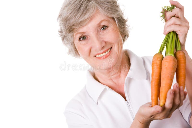 Portrait of elderly woman with ripe carrots smiling at camera over white background. Portrait of elderly woman with ripe carrots smiling at camera over white background