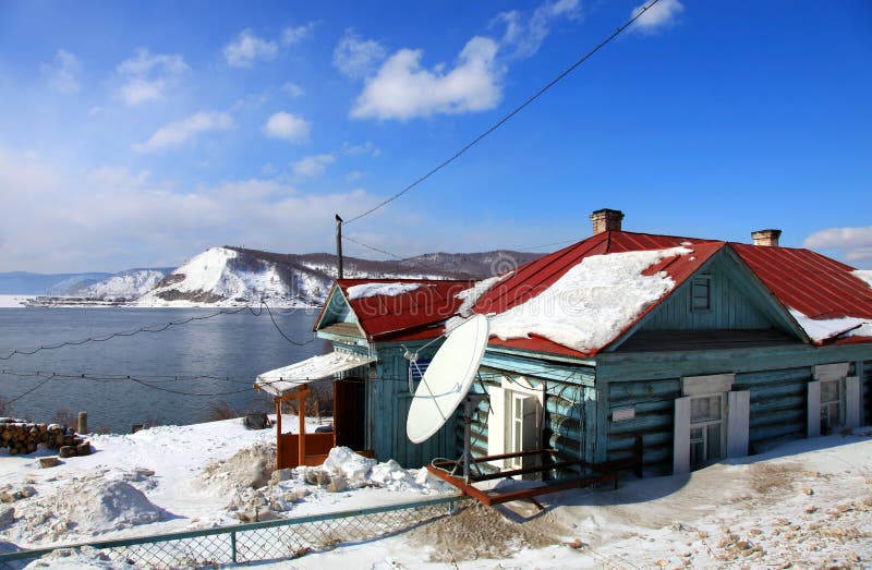 Rural house. Winter. Baikal Lake on background. Rural house. Winter. Baikal Lake on background.