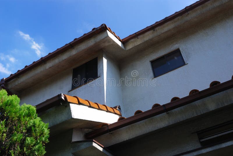 Rural house background with tile roof, two windows, blue sky and green bush. Rural house background with tile roof, two windows, blue sky and green bush
