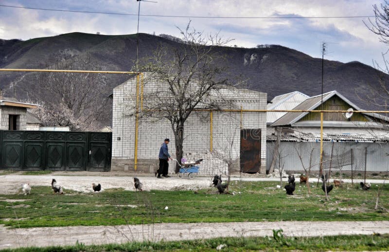 The rural house and villagers with poultry, hens in the Karachay-Cherkess Republic. The rural house and villagers with poultry, hens in the Karachay-Cherkess Republic