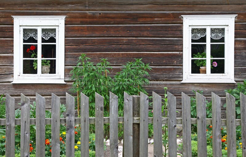 Picture of an old rural house with two windows and the wooden fence. Picture of an old rural house with two windows and the wooden fence