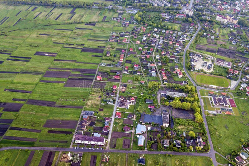 Landelijk landschap op de lente of de zomerdag Satellietbeeld van groene en geploegde gebieden, dorp of rijtjeshuisdaken en wegen royalty-vrije stock fotografie Landelijk landschap op de lente of de zomerdag Satellietbeeld van groene en geploegde gebieden, dorp of rijtjeshuisdaken en wegen royalty-vrije stock fotografie