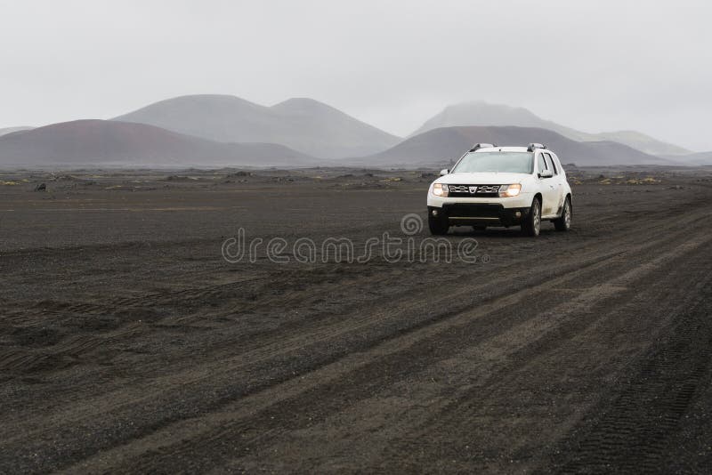 LANDMANNALAUGAR, ISLÂNDIA - EM AGOSTO DE 2018: Condução de carro no campo de lava preto na estrada à área de Landmannalaugar, Isl fotos de stock LANDMANNALAUGAR, ISLÂNDIA - EM AGOSTO DE 2018: Condução de carro no campo de lava preto na estrada à área de Landmannalaugar, Isl fotos de stock