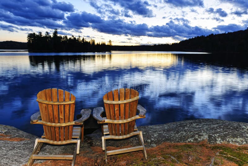 Wooden chairs at sunset on lake shore