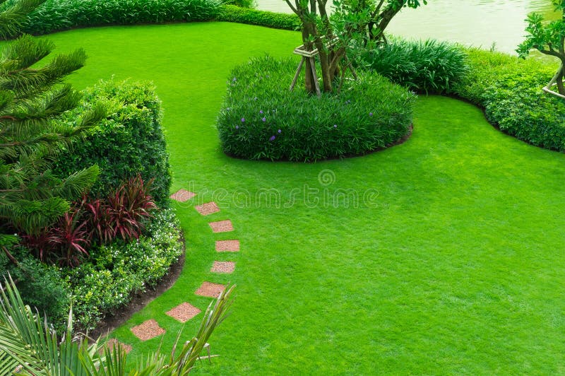 Beautiful garden beside the lake Walkway stone sheet with garden. landscape design freshly mowed lawn. top-view garden landscape design with paths intersecting bright. green grass shrub lawn care service