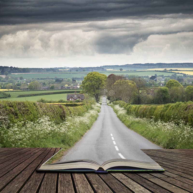 Landscape image of empty road in English countryside with dramatic stormy sky overhead concept coming out of pages in open book