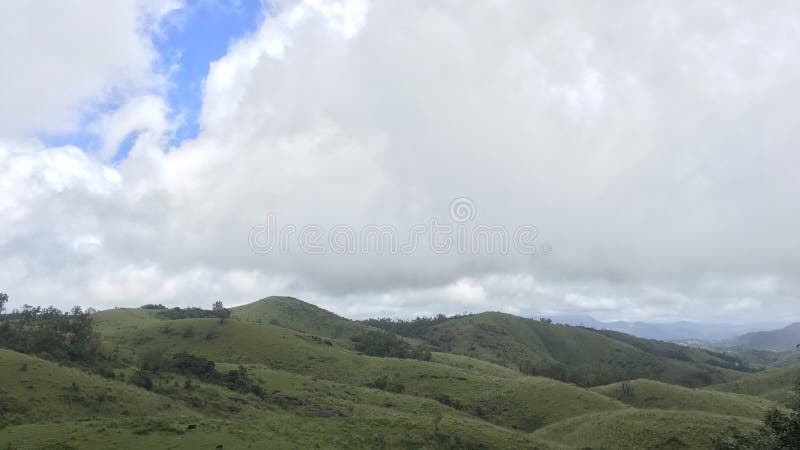 Landscape of Clouds passing over mountains covered in grass stock photography