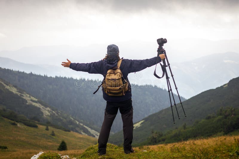 Hiker with camera and tripod enjoying nature