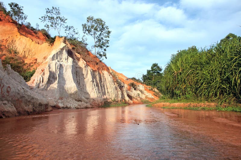 Landscape with red river between rocks and jungle. Vietnam