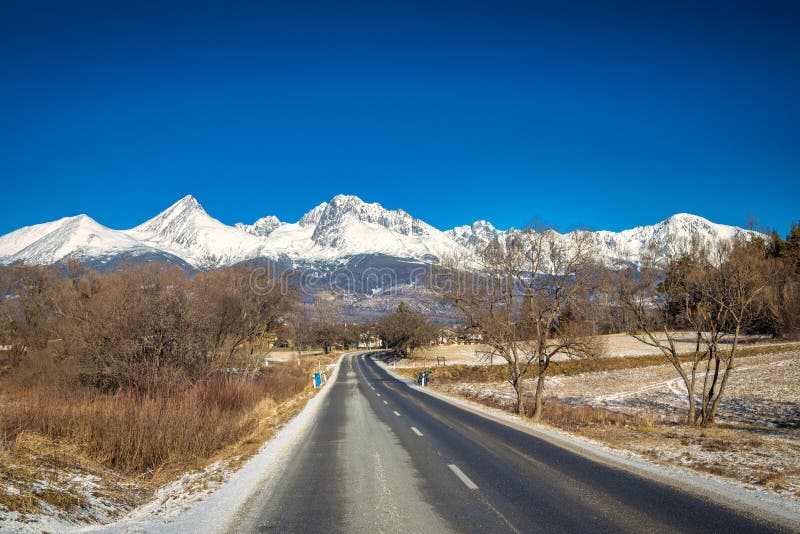 Landscape with a road leading to the snowy mountains
