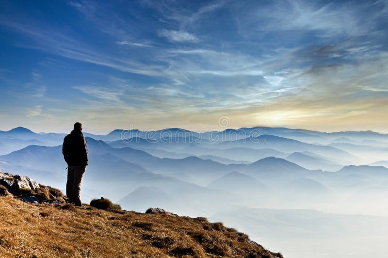 Krajina pohled na zamlžené horské kopce a silueta muže, Slovensko