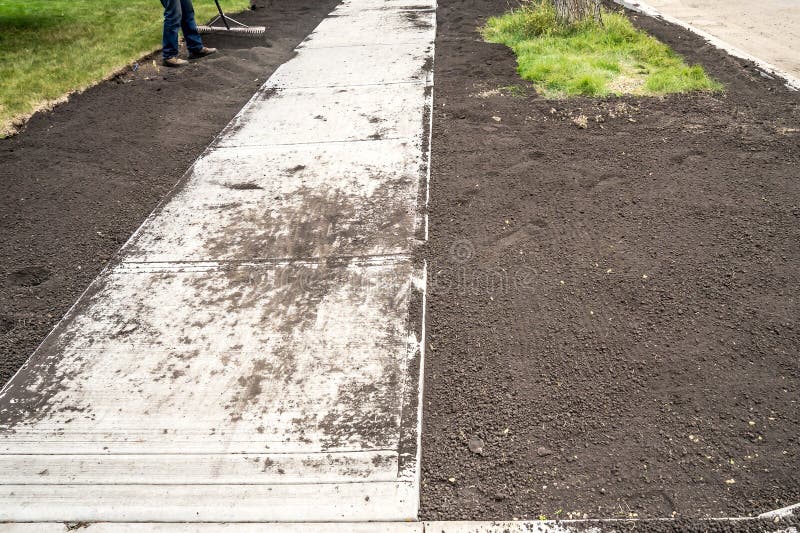 Landscaping Work with Top Soil at Sidewalk Construction Site Stock