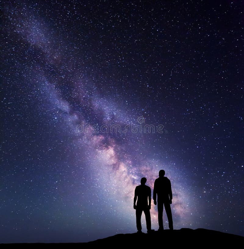 Silhouette of a family on the mountain. Father and a son on the background of Milky Way. Night landscape. Beautiful Universe. Space. Travel background with sky full of stars. Silhouette of a family on the mountain. Father and a son on the background of Milky Way. Night landscape. Beautiful Universe. Space. Travel background with sky full of stars