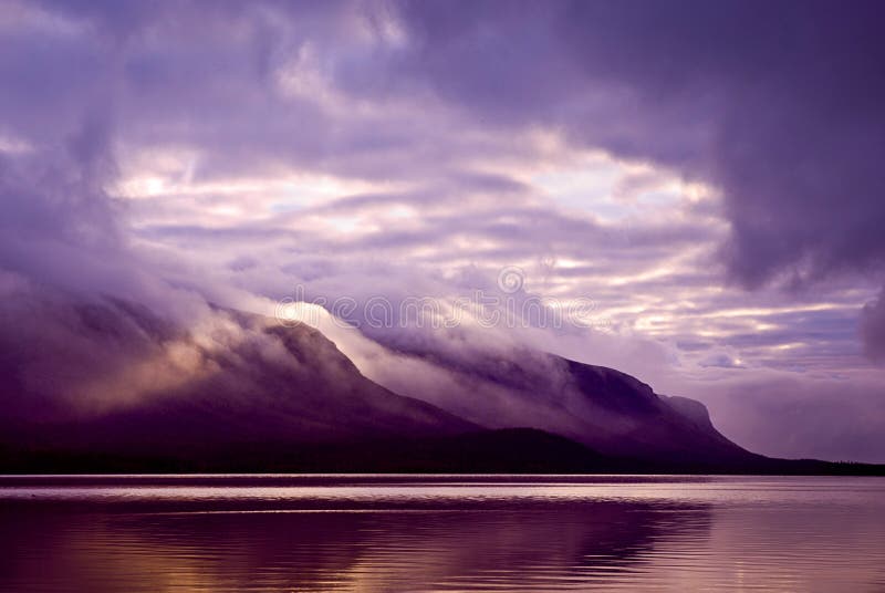 Landschap. Bergen en meer in mist in ochtend met purper col. royalty-vrije stock foto Landschap. Bergen en meer in mist in ochtend met purper col. royalty-vrije stock foto