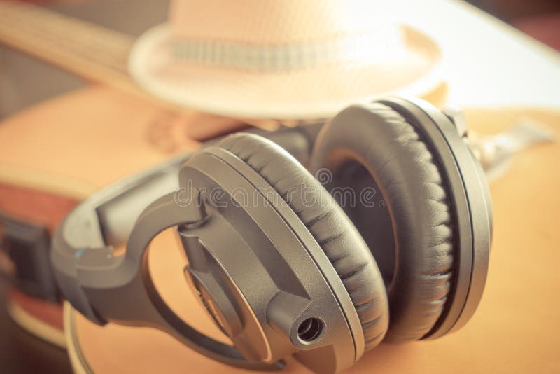 Landsgitarr med hatten och headphonen royaltyfria foton Landsgitarr med hatten och headphonen royaltyfria foton