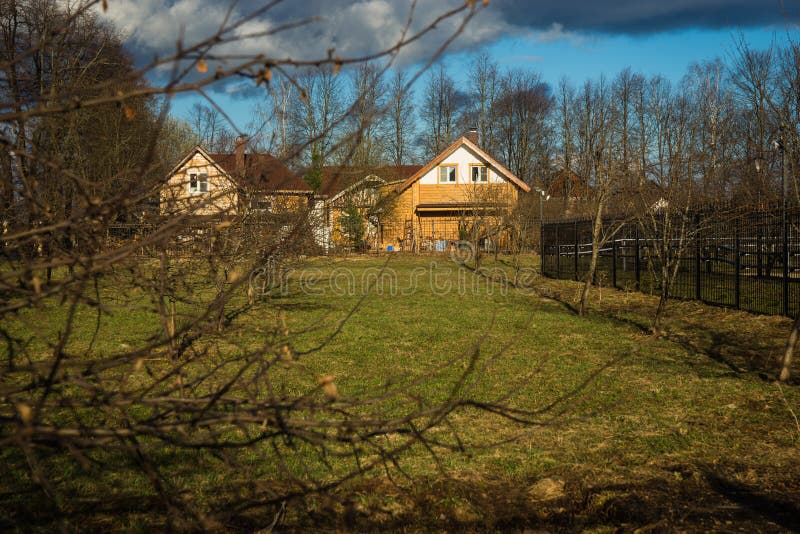Landshus med en trädgård av fruktträd i vår arkivbild Landshus med en trädgård av fruktträd i vår arkivbild