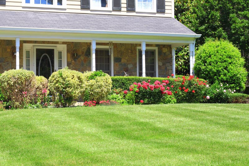 House with porch and flowerbed landscaping. House with porch and flowerbed landscaping.