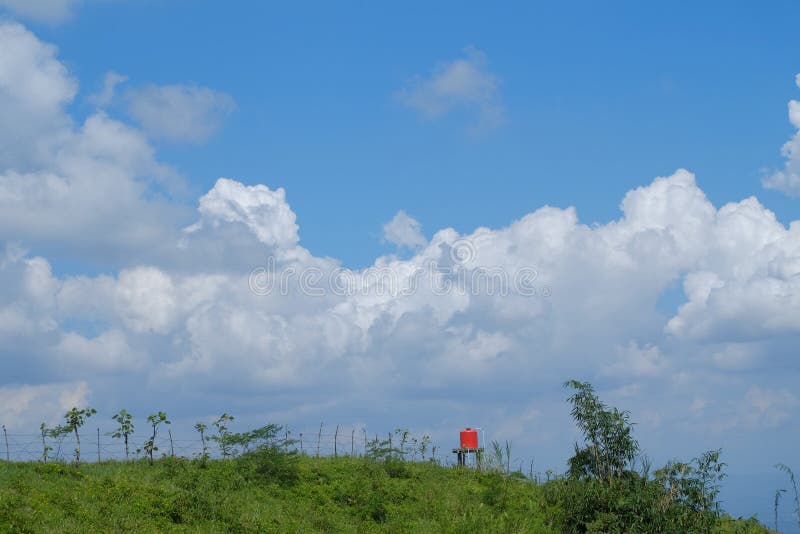 Landskapsikt p? kullen med bl? himmel och det vita f?r moln orange watterfl?det ocks? royaltyfria bilder Landskapsikt p? kullen med bl? himmel och det vita f?r moln orange watterfl?det ocks? royaltyfria bilder