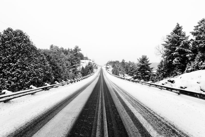 Landstraße im Winter mit Leitschienen lizenzfreie stockfotos Landstraße im Winter mit Leitschienen lizenzfreie stockfotos