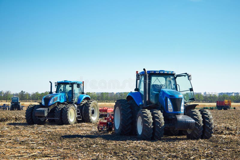 Modern agricultural machinery, tractors under a blue sky, agricultural machines, cultivation of the soil on the farm, a tractor working in a field, agricultural machinery in the work. Modern agricultural machinery, tractors under a blue sky, agricultural machines, cultivation of the soil on the farm, a tractor working in a field, agricultural machinery in the work