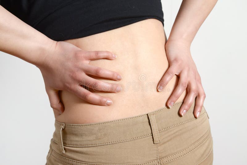Lange Arbeitszeiten und Gesundheit Junge Frau mit Rückenschmerzen Frau mit Rückenschmerzen auf Grau lizenzfreie stockfotos Lange Arbeitszeiten und Gesundheit Junge Frau mit Rückenschmerzen Frau mit Rückenschmerzen auf Grau lizenzfreie stockfotos