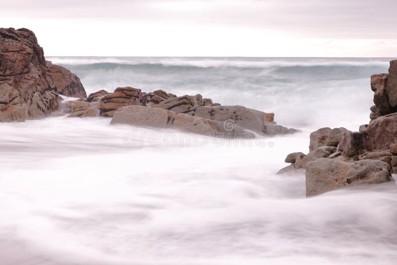 LANGE BELICHTUNGS-FOTOGRAFIE AUF EINEM STRAND MIT WELLEN GESCHLAGENEN FELSEN stockfotografie LANGE BELICHTUNGS-FOTOGRAFIE AUF EINEM STRAND MIT WELLEN GESCHLAGENEN FELSEN stockfotografie