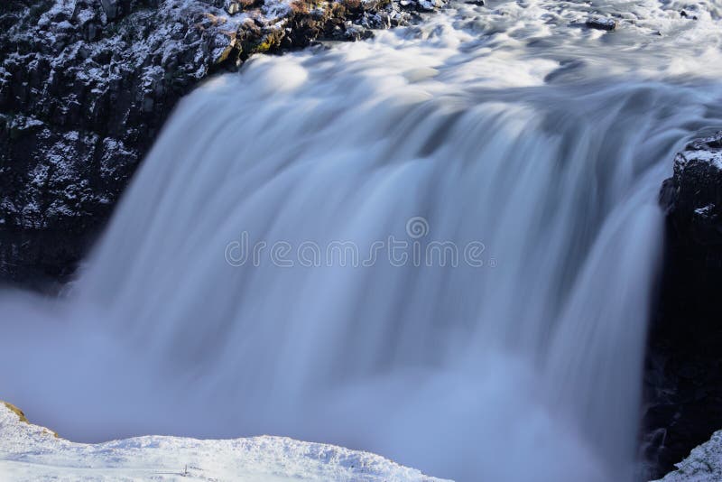 Lange Exposition gegenüber massivem Wasserfall im Winter lizenzfreies stockfoto
