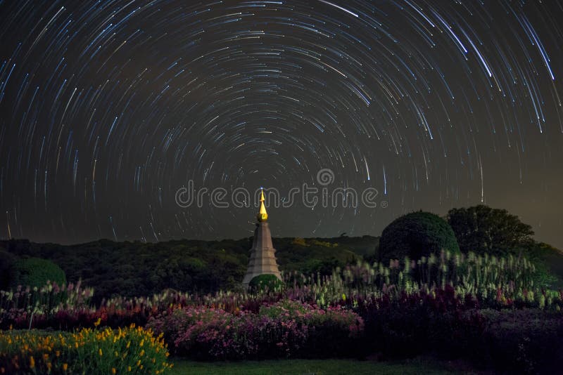 Lange sterrenslepen rond het noordenster over tempel, Thailand stock fotografie Lange sterrenslepen rond het noordenster over tempel, Thailand stock fotografie