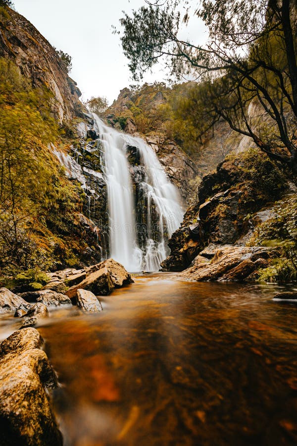 Langer Belichtungsschuß eines riesigen Wasserfalls mitten im Wald im Herbst stockbilder